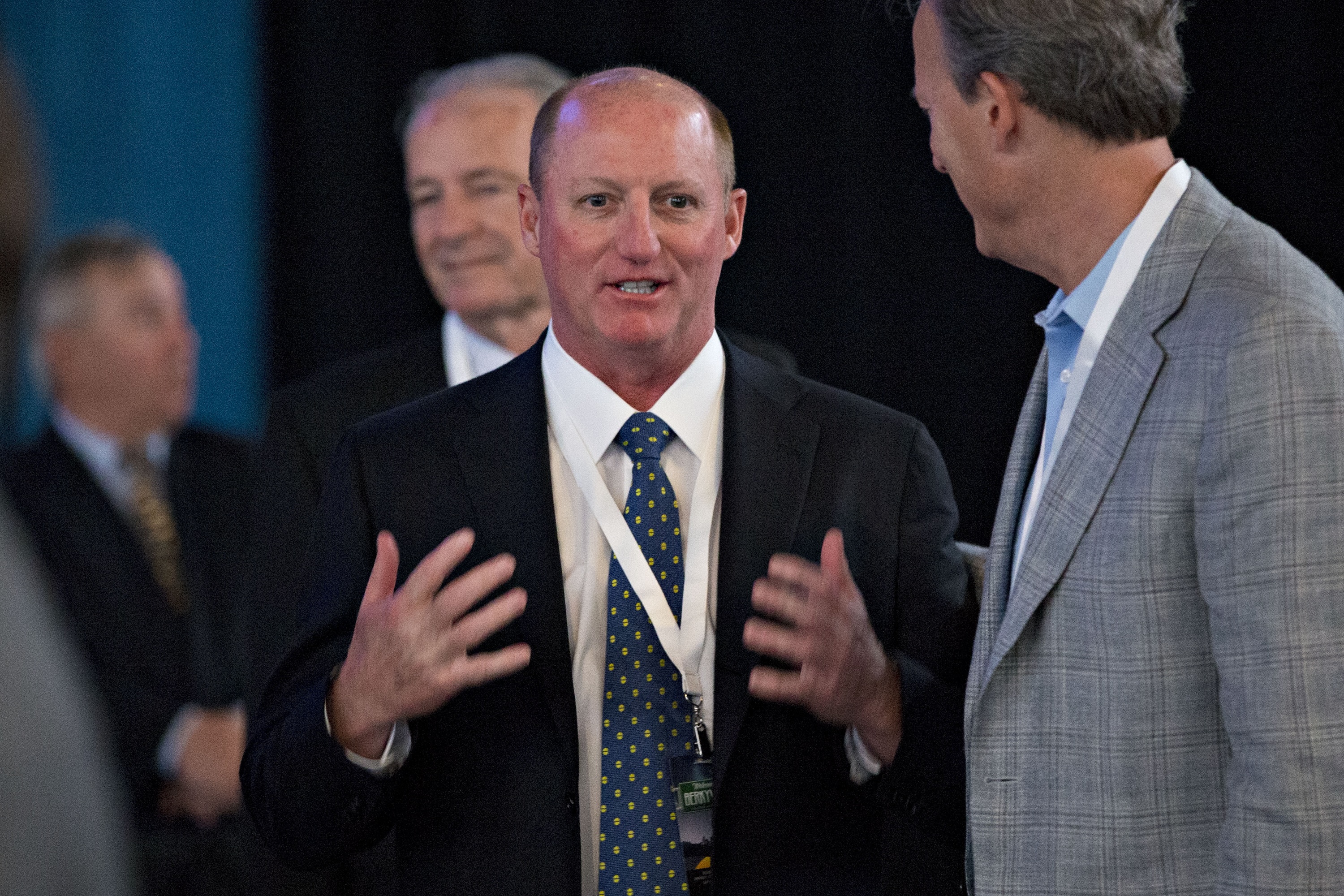 Greg Abel, chairman and chief executive officer of Berkshire Hathaway Energy Co., center, speaks with attendees before the start of the Berkshire Hathaway Inc. annual meeting in Omaha, Nebraska, U.S., on Saturday, May 6, 2017. Warren Buffett, chairman and chief executive officer of Berkshire Hathaway, said during the company's investors gathering that he's more inclined than usual this year to sell some assets because the tax advantage could soon diminish for divesting securities at a loss. Photographer: Daniel Acker/Bloomberg