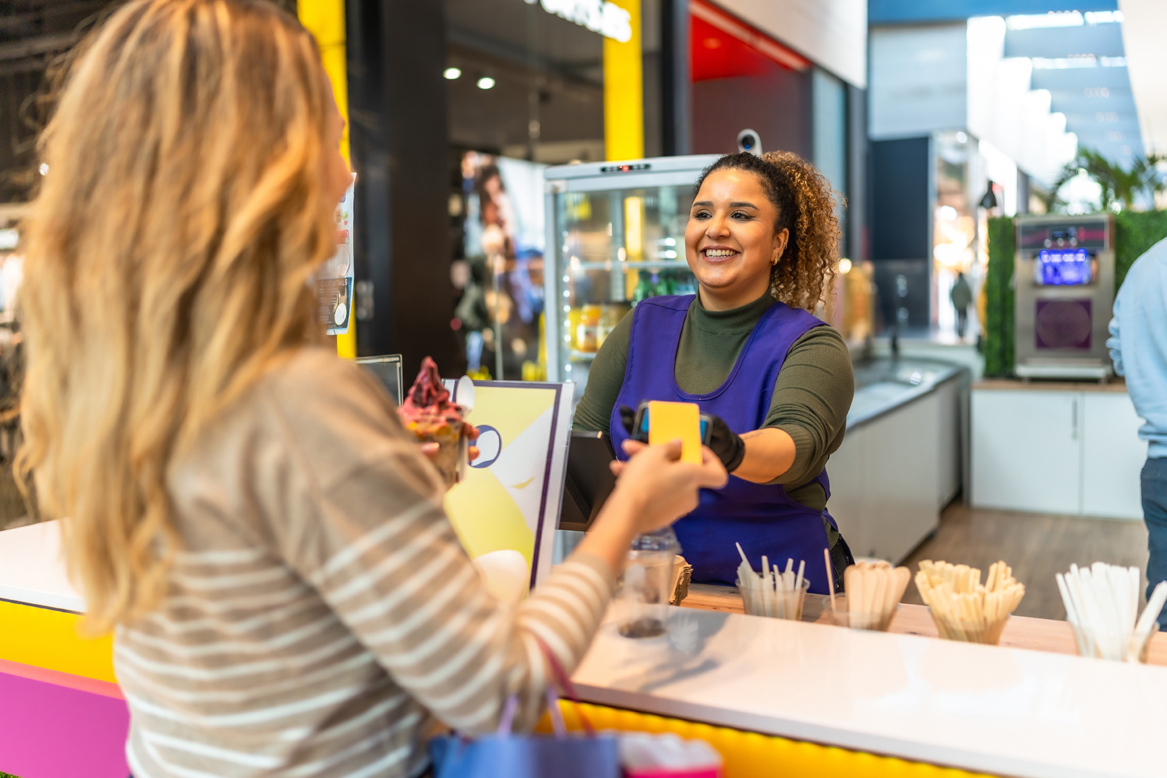 Customer completing a fast contactless payment with a friendly cashier